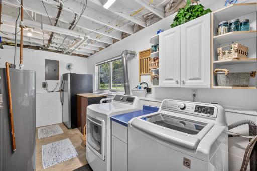 Convenient laundry area with cabinetry and additional storage.