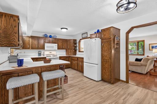 Brand-new flooring complements the kitchen's abundant cabinetry and generous workspace.