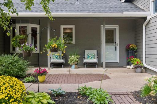 Large open front patio with lush perennial plantings
