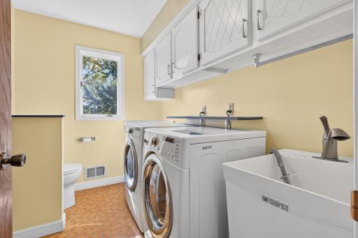 Main floor laundry room with cabinetry, laundry sink, and a toilet too. All living facilities are on the main level