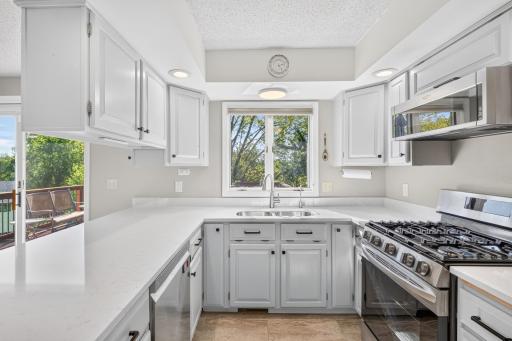 Bright and functional kitchen offers abundant cabinetry, generous prep space and a large window overlooking the backyard and surrounding mature trees