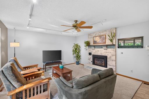 Spacious family room offers a comfortable gathering space centered around a brick fireplace with a raised hearth and abundant natural light