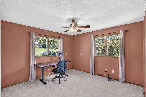 Spacious bedroom offers flexibility for a home office or a guest room with windows on two sides
