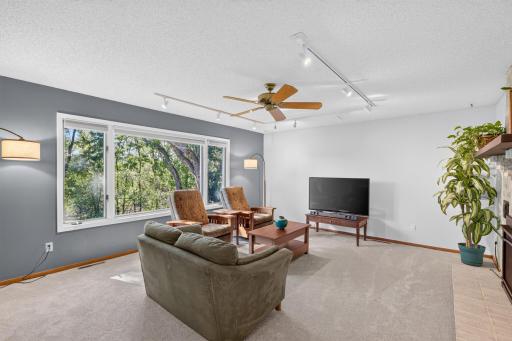 Large windows bring the outdoors in and a brick fireplace creates a warm focal point for relaxing and gathering