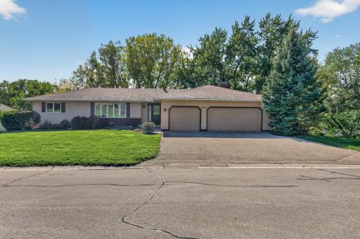 Classic rambler design with a spacious 3-car garage, brand new front door, and beautifully maintained lawn and landscaping