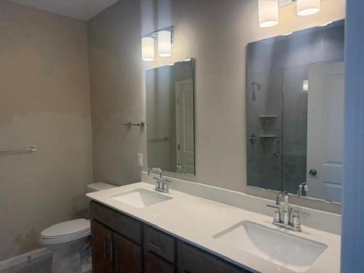 Double vanity with sleek countertops and ample storage provides both function and styleâperfect for shared use while maintaining personal space.