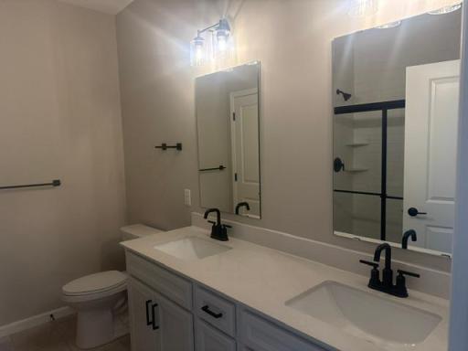 Double vanity with sleek countertops and ample storage provides both function and styleâperfect for shared use while maintaining personal space.