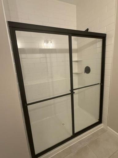 Elegant tilework and modern fixtures elevate the walk-in shower, offering a sleek, spa-inspired design that feels both timeless and on-trend.