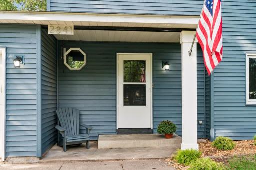 Covered front entry with space for a chair and seasonal accents.