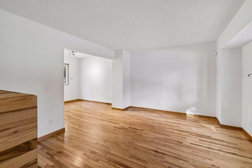 Hardwood flooring connects the bright living and dining spaces.