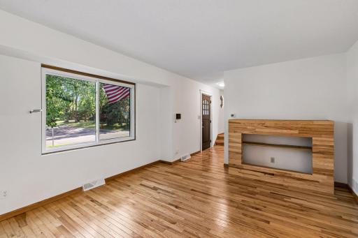 Living room with a large front window and natural wood accents.