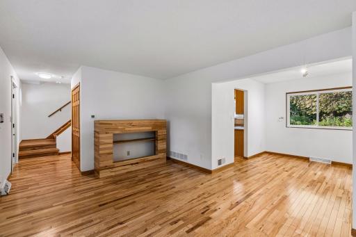 Living room opens to the dining area, with stairs leading to the upper level.