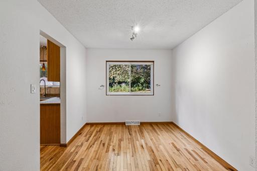 Dining area with hardwood flooring and convenient kitchen access.