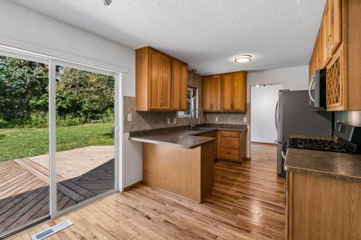 Sliding glass doors connect the kitchen’s casual dining area to the backyard deck.