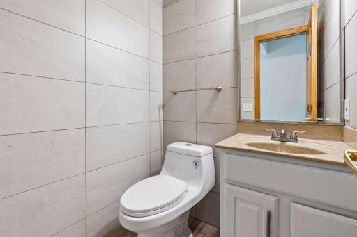 alf bath with tile finishes and a vanity with storage.