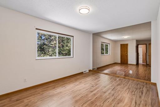 Upper-level primary bedroom with hardwood flooring and a mirrored accent wall.