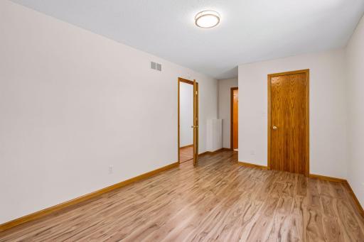 Alternate view of the primary bedroom and its hardwood flooring.