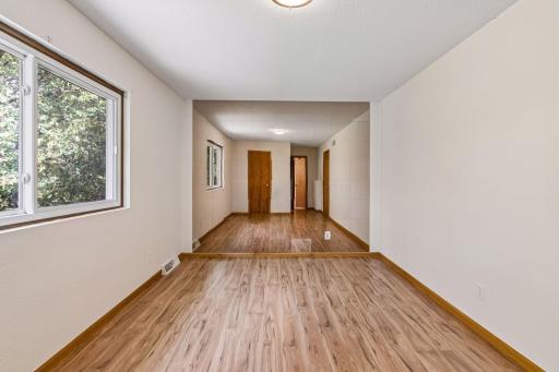 Primary bedroom with a large window and mirrored accent wall.