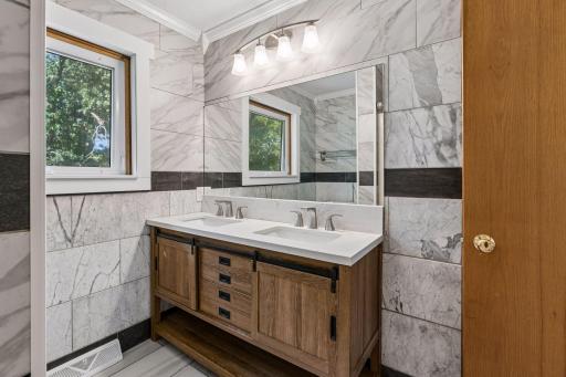 Double-sink vanity with drawers, sliding cabinet doors, and open lower storage.