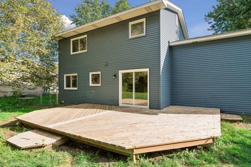 Rear exterior showing the deck and sliding-door access to the kitchen.