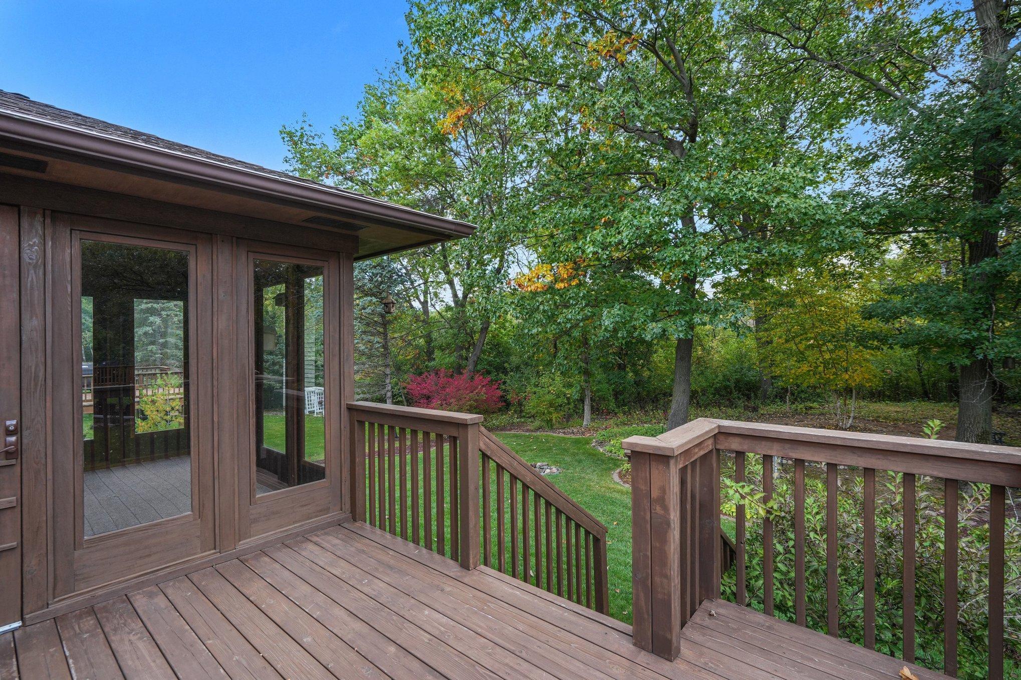 Deck off porch overlooking backyard with grill nuk