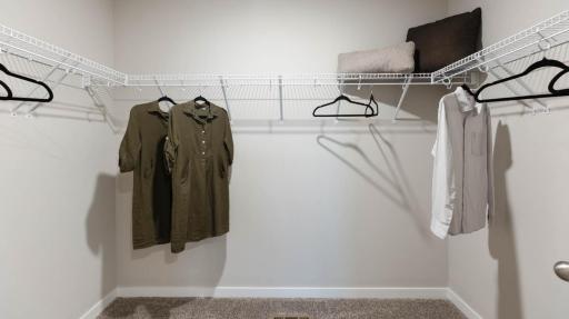 Room for every season of your wardrobe in this spacious walk-in closet with ample shelving and storage. *Photo of similar home. Virtually staged.