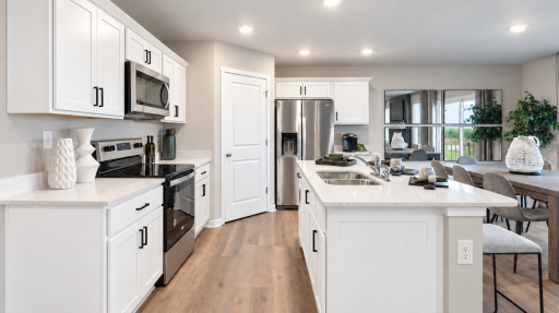 The perfect gathering space, featuring a large island, abundant cabinetry, and sleek stainless steel appliances. *Photo of similar home. Virtually staged.