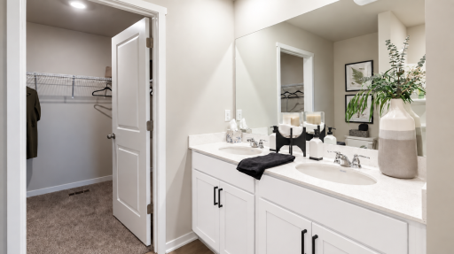 Dual vanities, a spacious 5-foot shower, and a convenient walk-through design make this primary bath both stylish and functional. *Photo of similar home. Virtually staged.