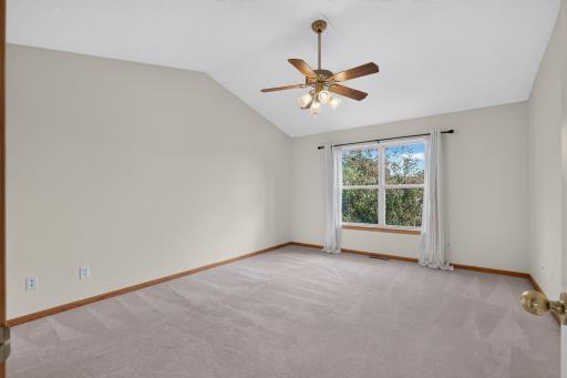 Vaulted ceilings in the Primary bedroom with ceiling fan & light fixture.