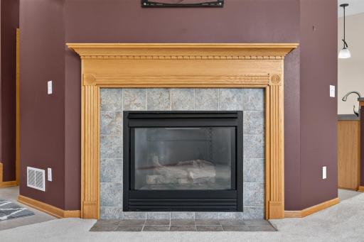 Gas fireplace with ceramic tile surround and wood mantle
