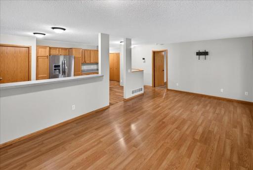 View of living room area and kitchen breakfast bar from informal dining room