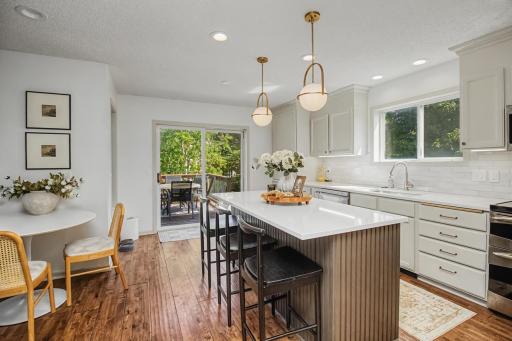 Updated kitchen features bright cabinetry, hard surface countertops and an oversized center island.