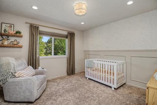 Second upper-level bedroom with plush carpeting, neutral tones, and charming finishes.