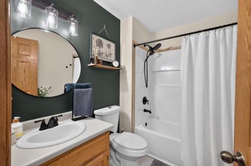 Updated full bath features a fresh, modern look with contrasting finishes.