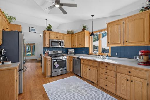 Open eat-in kitchen features newer stainless steel appliances and plenty of cabinetry.
