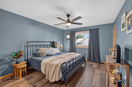 Primary bedroom boasts hard surface floors and a ceiling fan for added comfort.