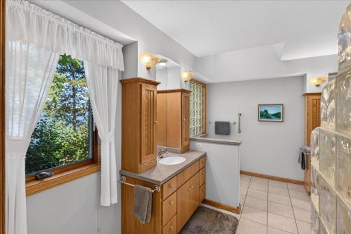 Spacious Bathroom with Dual Vanities, Soaking Tub and Glass Block Details