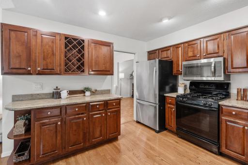 Rich wood cabinets, built-in wine rack, and stainless appliances