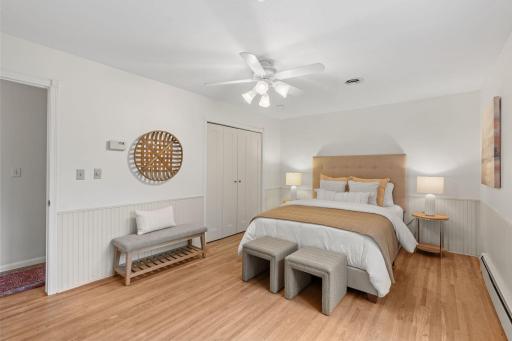 Primary bedroom with hardwood floors and ceiling fan
