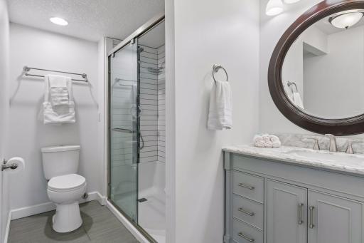 Updated three-quarter bath with glass-enclosed shower and stylish vanity completes the lower-level living space.