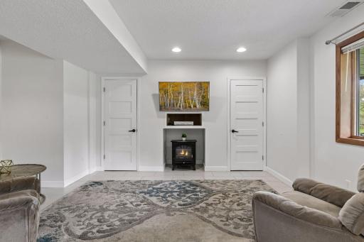 Bright and comfortable lower-level living room with a cozy fireplace and plenty of space to relax.