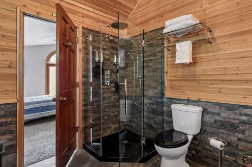 Impressive walk-in shower with multiple shower heads and glass enclosure - another standout feature of the spa-like primary suite.