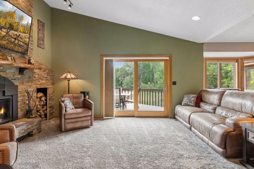 Another view of the living room highlights the large sliding glass door to the deck, creating an easy indoor-outdoor connection and bringing the wooded setting into the home.