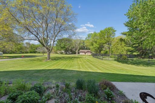 The meticulously landscaped yard is tilled, leveled, and hydro-seeded, with a full irrigation system for the lawn, flower beds, and vegetable garden.