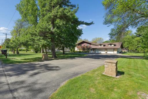 Front view of the property featuring a horseshoe-shaped asphalt driveway.