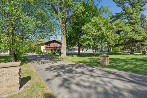 Alternate front view showcasing the circular horseshoe driveway and beautifully landscaped setting.