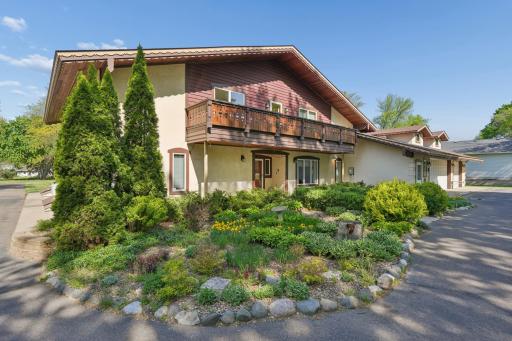 Close-up of the home's charming front faÃ§ade surrounded by lush, professionally designed landscaping.