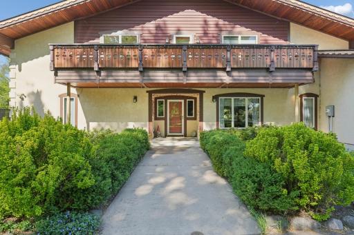 Close-up view of the welcoming front entry, featuring a custom front door and elegant balcony above.