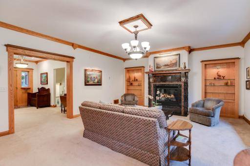 Another view of the living room featuring a cozy gas fireplace and built-in shelving, 9-foot ceilings, stunning 11-inch smooth cedar trim.