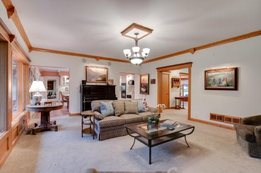 Alternate view of the inviting living room highlighted by a cozy gas fireplace, custom built-in cabinetry, soaring 9-foot ceilings, rich 11-inch smooth cedar trim, Andersen Perma-Shield windows, and a seamless connection to the kitchen.